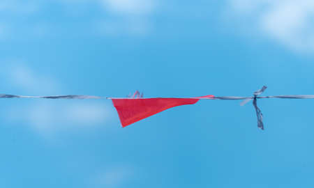 colorful flags banners against blue saturated skyの写真素材