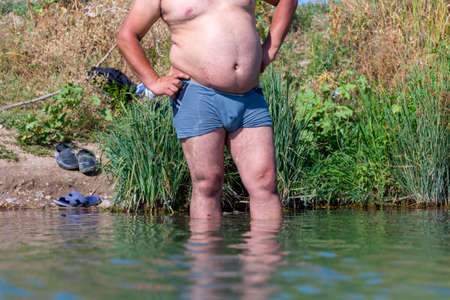 A young man standing in the water on the lake