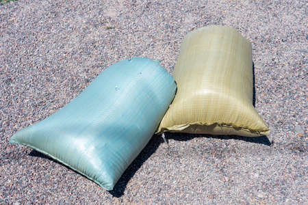 two full sacks lie on the ground
