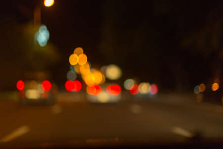 Artistic style - Defocused urban abstract texture ,blurred background with bokeh of city lights from car on street at night, vintage or retro color toneの写真素材