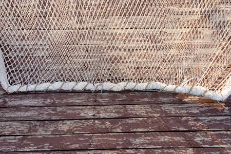 Background of textured fishing net on a wooden wall backgroundの写真素材