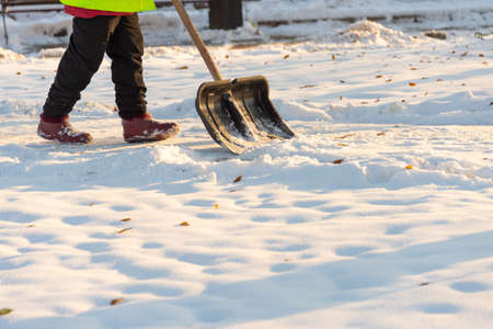 Employees of municipal services in a special form clear the snow from the sidewalkの写真素材