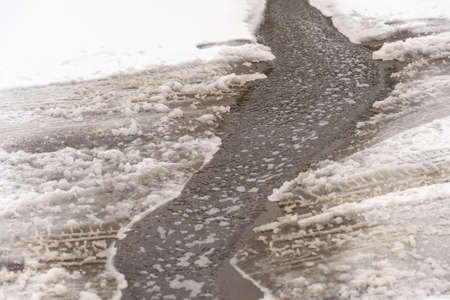 A detailed look at the water runs under the ice, the water from the tap flows into the streamの写真素材