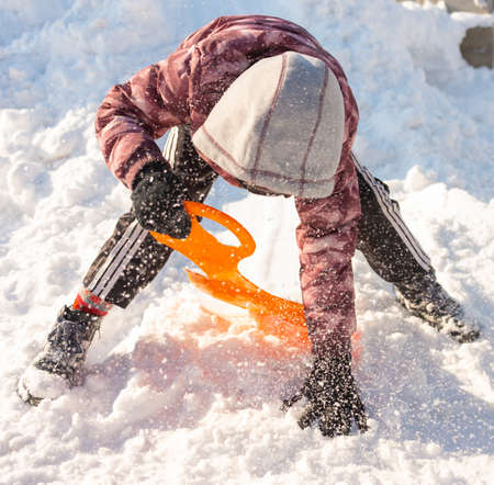 Cute boy sledding in the snowの写真素材