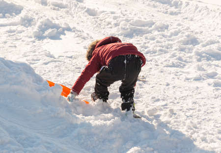 Cute boy sledding in the snowの写真素材