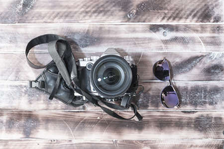 retro camera on a wooden table and glassesの写真素材