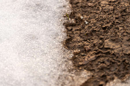 the snow is melting and the ground is under itの写真素材