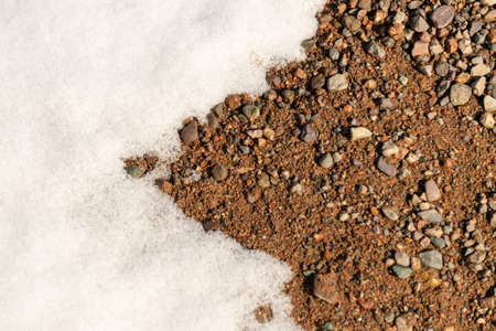 the snow is melting and the ground is under itの写真素材