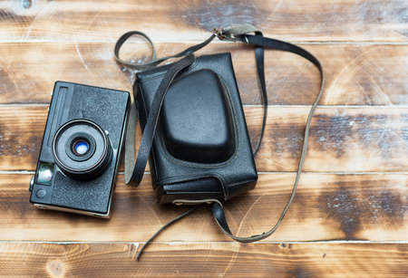 Retro camera on wood table background, vintage color toneの写真素材