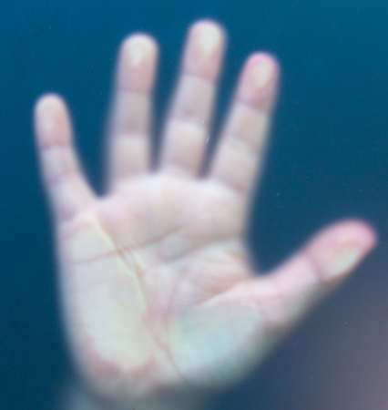 boy's hand behind the glass