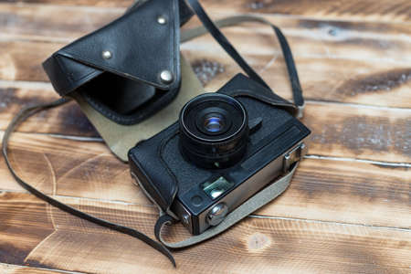 Retro camera on wood table background, vintage color toneの写真素材