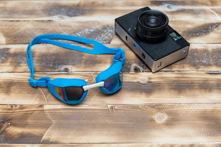 retro camera on a wooden table and swimming gogglesの写真素材