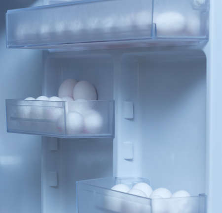 chicken eggs on a plastic tray in the fridgeの写真素材
