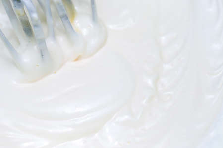 Mixing white egg cream in a bowl with a motor mixer, baking cakeの写真素材