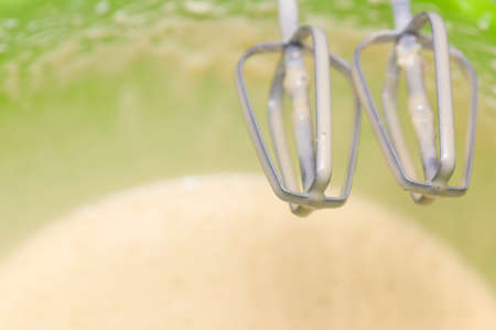 Mixing white egg cream in a bowl with a motor mixer, baking cakeの写真素材
