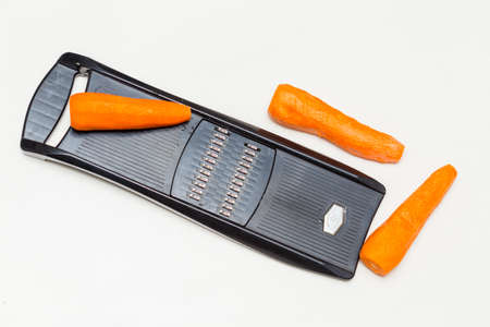 grater and carrots on a white backgroundの写真素材