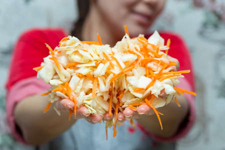 girl prepared a cabbage salad and points to the cameraの写真素材