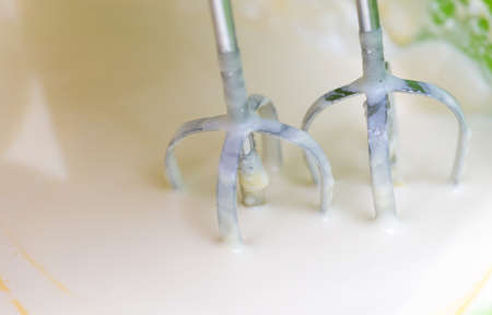Mixing white egg cream in a bowl with a motor mixer, baking cakeの写真素材