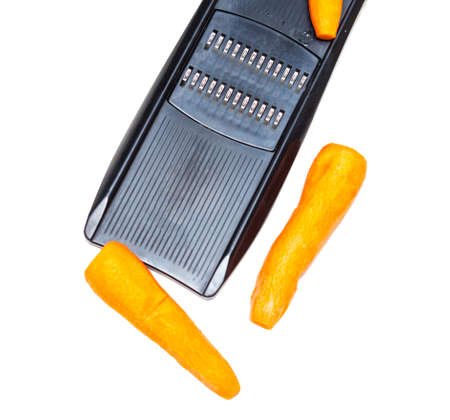 grater and carrots on a white backgroundの写真素材