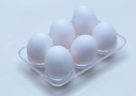 six chicken eggs in a plastic tray from the fridgeの写真素材