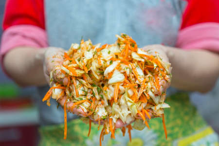 girl prepared a cabbage salad and points to the cameraの写真素材