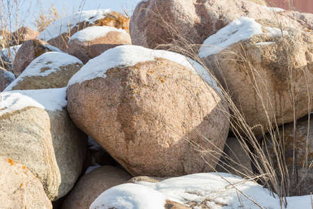 huge stones in the snow of different shapes and sizes, natural stone, winter backgroundの写真素材