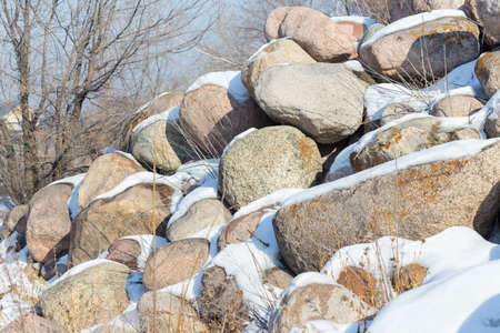 huge stones in the snow of different shapes and sizes, natural stone, winter backgroundの写真素材