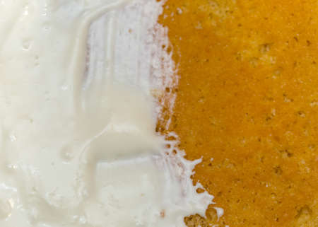 application of milk cream on the surface of the sweet cakeの写真素材