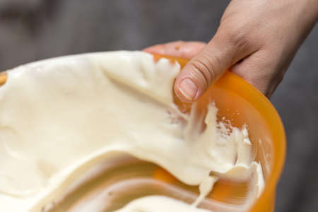 milk cream on dishes in the hands of manの写真素材