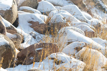 huge stones in the snow of different shapes and sizes, natural stone, winter backgroundの写真素材