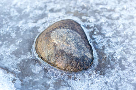 stone on ice in a frozen lakeの写真素材