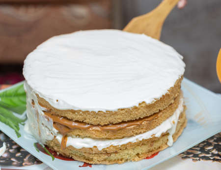 application of milk cream on the surface of the sweet cakeの写真素材