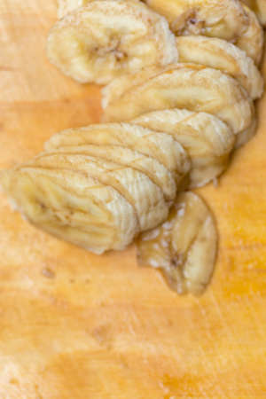 Banana slices on wooden board backgroundの写真素材