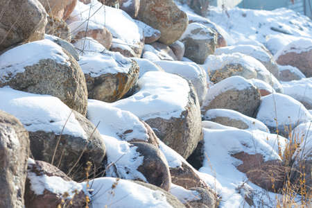 huge stones in the snow of different shapes and sizes, natural stone, winter backgroundの写真素材