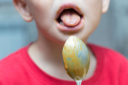 Boy lysate, traces of the remaining chocolate cream on a spoonの写真素材