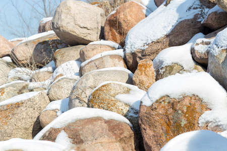 huge stones in the snow of different shapes and sizes, natural stone, winter backgroundの写真素材