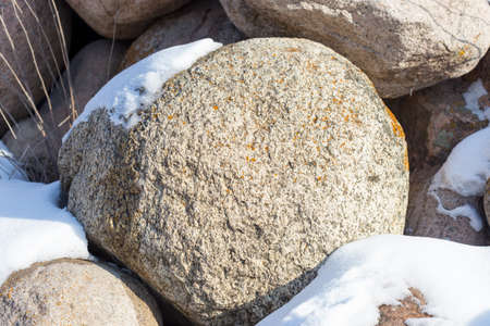 huge stones in the snow of different shapes and sizes, natural stone, winter backgroundの写真素材
