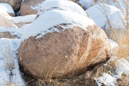 huge stones in the snow of different shapes and sizes, natural stone, winter backgroundの写真素材