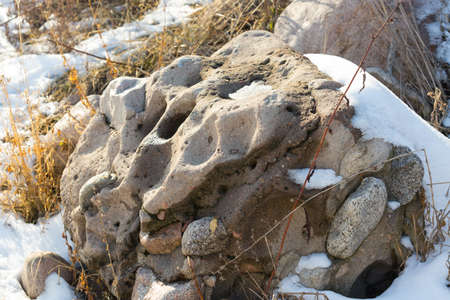 huge stones in the snow of different shapes and sizes, natural stone, winter backgroundの写真素材