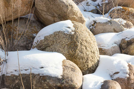 huge stones in the snow of different shapes and sizes, natural stone, winter backgroundの写真素材
