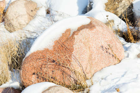 huge stones in the snow of different shapes and sizes, natural stone, winter backgroundの写真素材