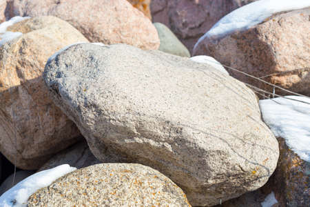 huge stones in the snow of different shapes and sizes, natural stone, winter backgroundの写真素材