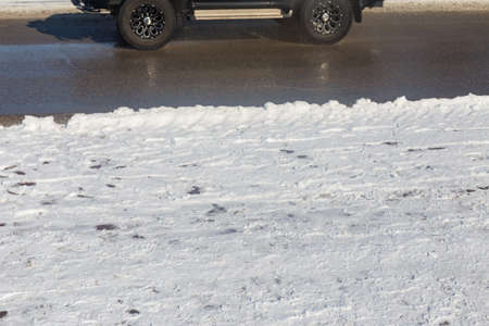 car drives in the winter on a dirty roadの写真素材