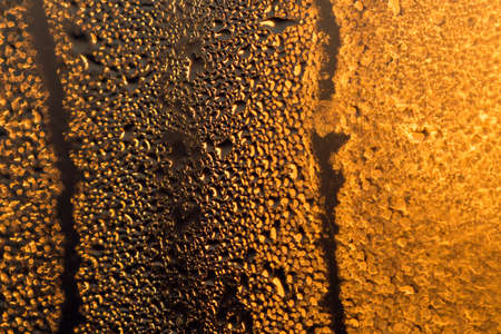 water drops on the glass surface at sunset, macroの写真素材
