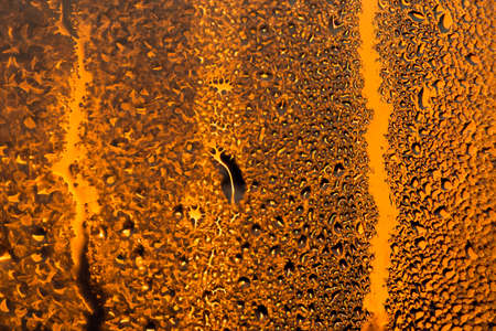 water drops on the glass surface at sunset, macroの写真素材