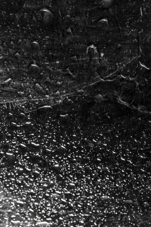 water drop on black . macro close up .raining glass isolated black backgroundの写真素材