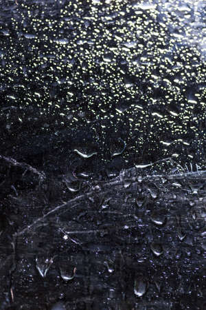 water drop on black . macro close up .raining glass isolated black backgroundの写真素材