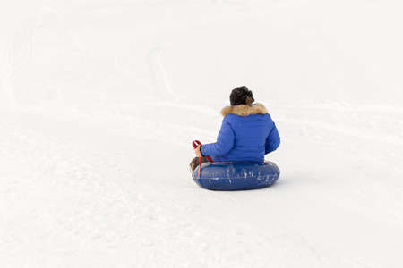 winter, leisure, sport, friendship and people concept - group of happy people sliding on the snow inflatable chambersの写真素材