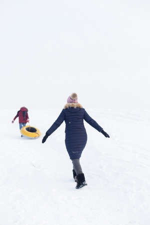 Portrait of a beautiful girl in blue jackets on the background of snow. Outdoor winter portraitの写真素材