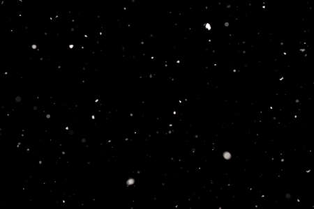 Snowstorm texture. Bokeh lights on black background, shot of flying snowflakes in the airの写真素材
